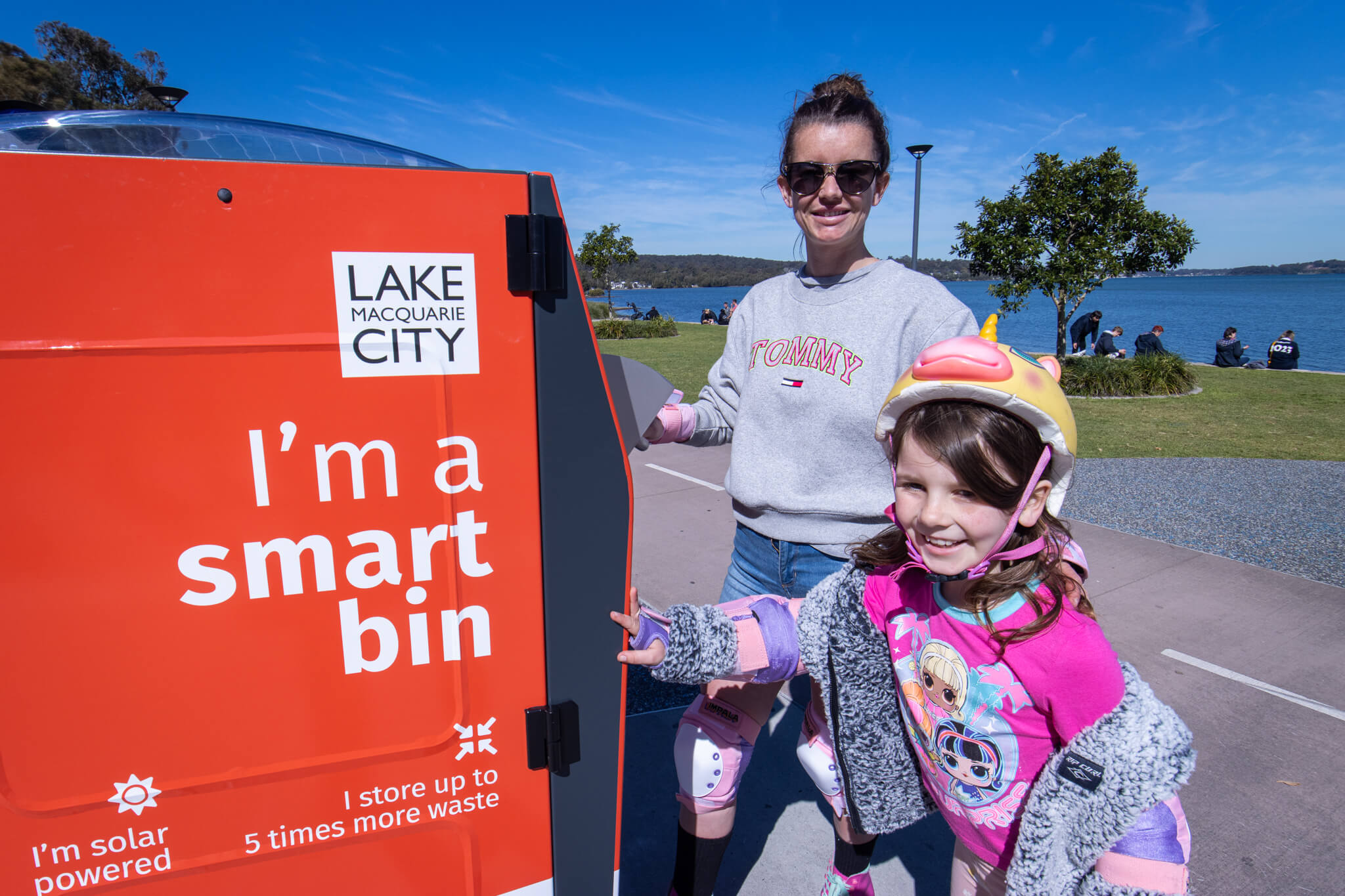 Elle Sharp and daughter Myra test out one of the new smart bins at Warners Bay foreshore